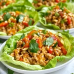 - 1 lb ground chicken - 1 tablespoon olive oil - 1 red bell pepper, finely diced - 1 small carrot, grated - 3 green onions, chopped - 1/4 cup sweet chili sauce - 2 tablespoons soy sauce - 1 tablespoon fresh lime juice - 1 teaspoon minced garlic - 1/2 teaspoon ground ginger - Chopped peanuts - Cilantro leaves - Sesame seeds Gather all these ingredients before you start cooking. The ground chicken forms the base of the dish, bringing rich flavor. Olive oil adds healthy fat, which helps with cooking. The red bell pepper gives a sweet crunch. Grated carrot adds color and texture. The green onions bring a fresh taste. The sauce combines sweet chili sauce with soy sauce for a savory kick. Fresh lime juice gives brightness to the mix. Minced garlic and ground ginger add depth and warmth. Together, these flavors create a delightful blend. Optional toppings like chopped peanuts, cilantro, and sesame seeds enhance the wraps. They add crunch and freshness, making each bite exciting. Feel free to mix and match your toppings based on your taste. With all these ingredients, you are ready to create a tasty meal that is fun to eat! {{ingredient_image_1}} Heat 1 tablespoon of olive oil in a large skillet over medium heat. Once hot, add 1 pound of ground chicken. Cook it for about 5 to 7 minutes. Stir it often until the chicken is browned and cooked all the way through. Next, stir in 1 finely diced red bell pepper, 1 grated small carrot, and 3 chopped green onions. Sauté the mix for 3 to 4 minutes. Cook until the veggies soften and blend well with the chicken. In a small bowl, whisk together 1/4 cup of sweet chili sauce, 2 tablespoons of soy sauce, 1 tablespoon of fresh lime juice, 1 teaspoon of minced garlic, and 1/2 teaspoon of ground ginger. Pour this sauce over the chicken and veggie mix in the skillet. Stir everything well and cook for an additional 2 to 3 minutes until it’s all heated through. Season with salt and pepper to taste. Remove the skillet from the heat and let the mixture cool slightly. To serve, spoon the chicken mixture into the separated leaves of butter lettuce or romaine. Enjoy each wrap as you bite into the fresh flavors and textures! - Ensuring chicken is fully cooked Cook ground chicken for 5-7 minutes until it turns brown. Use a meat thermometer to check for an internal temperature of 165°F (74°C). This ensures it is safe to eat. - How to avoid soggy lettuce Choose sturdy leaves like butter lettuce or romaine. Dry the leaves well after washing. Serve the filling warm but not hot to keep the lettuce crisp. - Plating and garnishing ideas Arrange the filled lettuce wraps on a large platter. This makes them look inviting. Add lime wedges around the platter for color and easy access. - Drizzling extra sauce for presentation Drizzle extra sweet chili sauce over the wraps. This adds a shiny, appealing look. It also gives guests a hint of the flavor. - Adjusting spice levels Want more heat? Add sliced fresh peppers or a sprinkle of chili flakes to the mix. For less spice, reduce the sweet chili sauce. - Recommended side dishes Serve these wraps with a side of jasmine rice or cucumber salad. These sides complement the wraps and add freshness. Pro Tips Use Fresh Ingredients: Fresh vegetables and herbs bring out the best flavors in your lettuce wraps. Opt for vibrant produce for a delicious crunch. Adjust Spice Levels: If you prefer a spicier kick, add some chopped chili peppers or a dash of hot sauce to the chicken mixture. Make Ahead: You can prepare the chicken mixture in advance and store it in the fridge. Just heat it up before serving for a quick meal. Experiment with Toppings: Try adding different toppings such as avocado, shredded cabbage, or even a drizzle of peanut sauce for a unique twist. {{image_2}} You can easily change the protein in this dish. Ground turkey works well as a leaner option. It has a mild flavor that blends nicely with the sweet chili sauce. You can also try ground beef for a richer taste. If you prefer a plant-based choice, tofu is a great pick. Crumble firm tofu and cook it like the chicken for a tasty vegetarian option. Want to switch up the flavor? You can make your own sweet chili sauce. Start with brown sugar, vinegar, and red pepper flakes. Mix in some garlic for added flavor. This homemade sauce can give your wraps a unique twist. If you want more heat, add sriracha or chili paste. This change can make your wraps even more exciting. Butter lettuce is not the only choice for wraps. Romaine lettuce is sturdy and adds a nice crunch. You can even use collard greens for a fun twist. If you want to skip the wraps, serve the chicken mixture over rice or quinoa. This adds a hearty base and makes it a complete meal. To keep your Sweet Chili Chicken Lettuce Wraps fresh, store them properly. Place the chicken mixture in a sealed container. You can keep the lettuce leaves separate to avoid sogginess. Refrigerate both parts right away. They will stay fresh for about three days. You can freeze the chicken mixture if you want to save some for later. Let it cool completely before placing it in a freezer-safe bag. Make sure to remove as much air as possible. It will last in the freezer for about three months. To eat, thaw it in the fridge overnight and reheat it on the stove. For best taste, eat the wraps within three days of cooking. If they smell off or look slimy, do not eat them. Always check for any discoloration or unusual textures. This ensures you enjoy your meal at its best! Sweet Chili Chicken Lettuce Wraps stay fresh in the fridge for about 3 days. Store them in an airtight container. If you want to keep them longer, freeze the chicken mixture. It lasts about 2-3 months in the freezer. Just remember to let it cool before freezing. Yes, you can use pre-cooked chicken. If you do, heat it in the skillet first. Then, add the veggies and sauce. You can also use rotisserie chicken or leftover grilled chicken. This saves time and adds flavor. You can make these wraps gluten-free. Use gluten-free soy sauce, like tamari. Check the sweet chili sauce label too. Always watch for cross-contamination. Clean your cooking tools and surfaces well before you start. You now have all the steps and tips to make great Sweet Chili Chicken Lettuce Wraps. With simple ingredients like ground chicken, veggies, and a tasty sauce, this dish is fun to cook. Remember to check your chicken and keep your lettuce fresh. Feel free to mix things up with different proteins or wraps, too. With these variations, you can make this recipe fit your tastes. Enjoy the process and the delicious wraps you create!